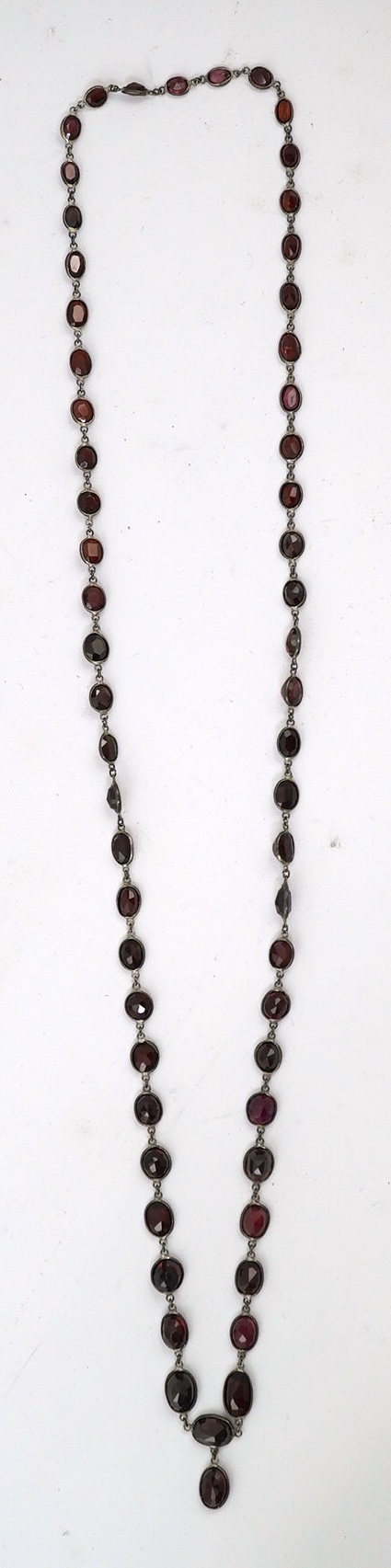 A Victorian silver and graduated oval cut two colour garnet set drop spectacle necklace, 74cm. Condition - poor to fair